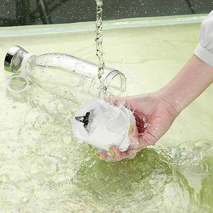 Portable blender being washed under running water for easy cleaning.