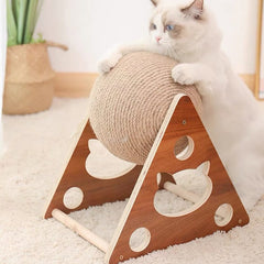 Cat playing with Sisal Rope Ball Scratcher on wooden triangular base.